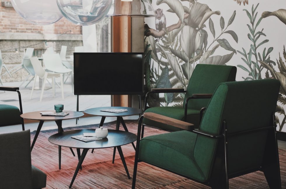 resurgence of wallpaper in a tropical plant print combined with green chairs in front of a large window