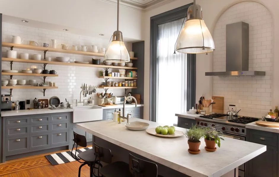 Nancy Meyers kitchen inspiration fromt he movie The Intern featuring blue cabinets, subway tile backsplash, open shelving, and a large island with a white countertop