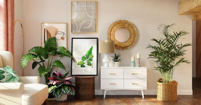 one of the Florida room ideas based on sunroom designs that features a white mid-century console, framed plant prints, circle rattan mirror, and large potted tropical plants
